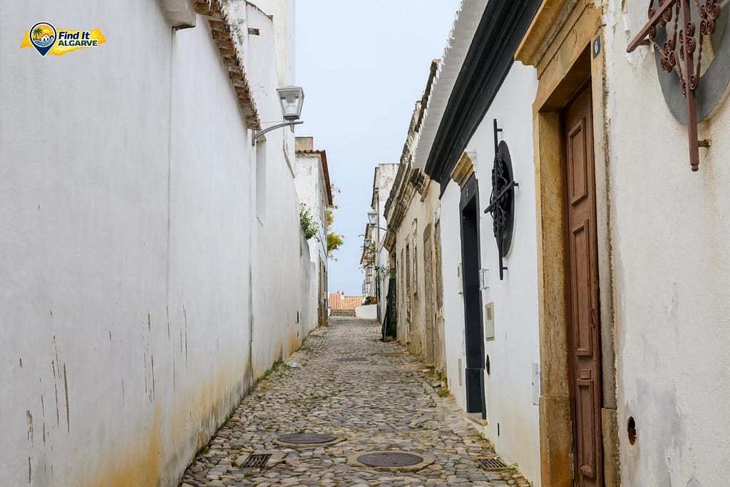 Traditional Algarve town street with whitewashed houses and cobbled streets
